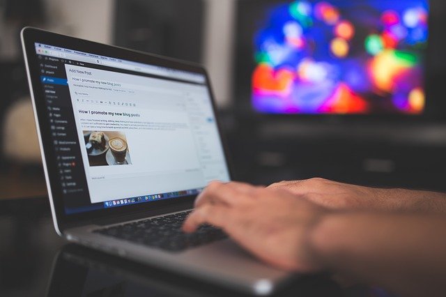 Hands typing on laptop